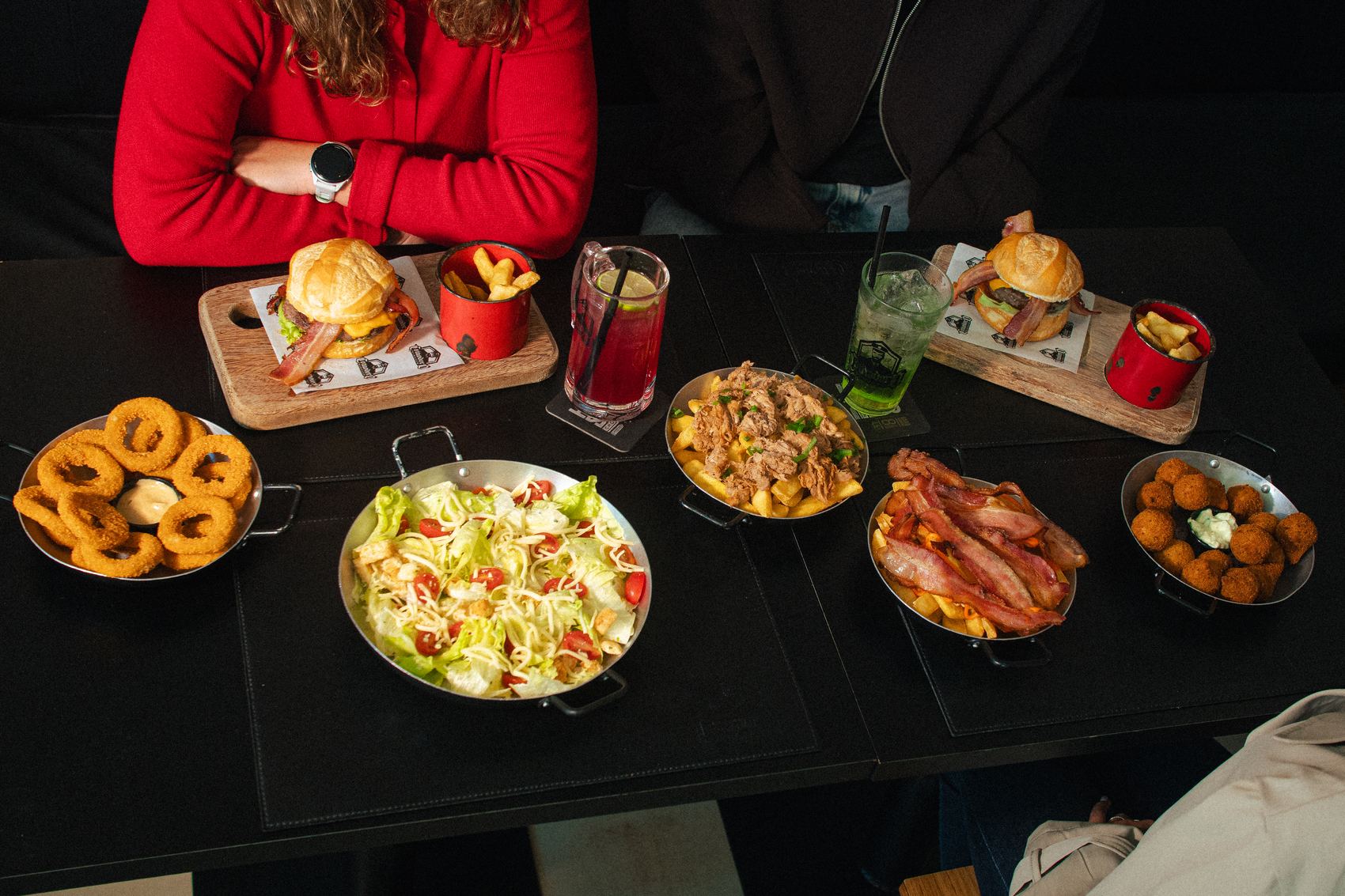 Mesa cheia de amigos no Comodoro: burguers, porções e drinks